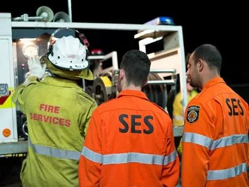 SES volunteers and a Fire brigade member by a fire truck
