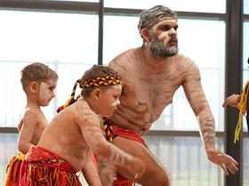 Aboriginal men dance in traditional outfits
