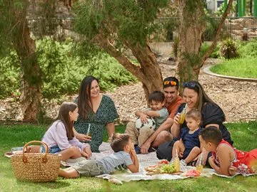 An extended family enjoy a picnic in a park
