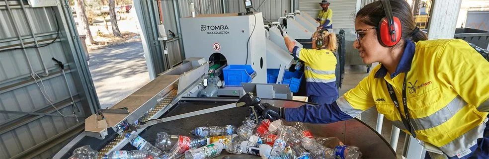 A worker separates cans and bottles at a cash for containers workshop
