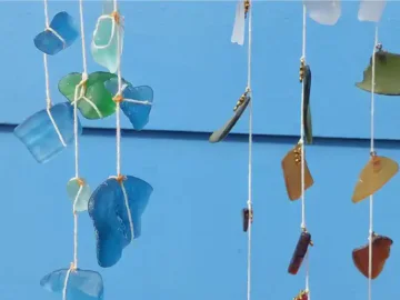 5 strands of rope with coloured sea glass entwined to each strand.