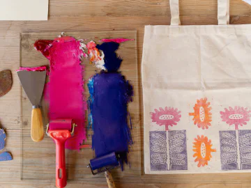 Two rubber paint rollers next to a printed tote bag.