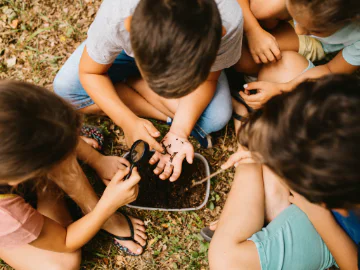 Children looking at worms in a bucket of soil