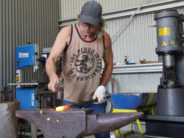 Caine Scott forging a piece of metal