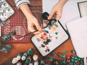 An artist painting a boardgame figurine