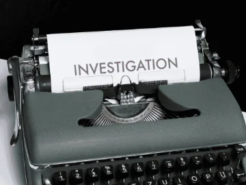 a typewriter displays the word investigation