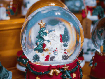 A snow globe containing Santa, a dog and a Christmas tree