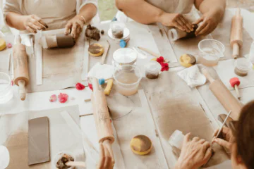 Artists working with clay at a table