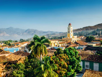A view over the city of Trinidad, Cuba with mountains in the background and blue sky