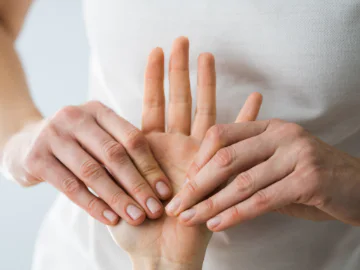 Hands massaging another hand
