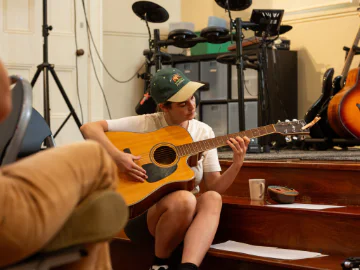 Musicians playing guitar and writing lyrics