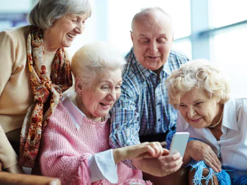 Seniors smiling using a mobile phone