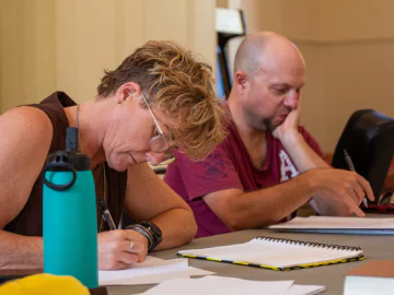 Musicians writing lyrics at a songwriting program