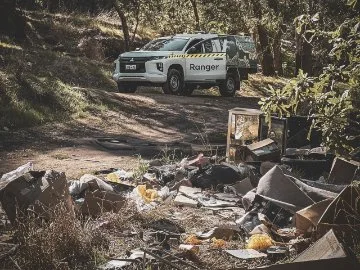 An abandoned car with dumped rubbish