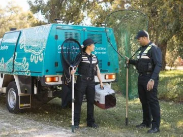 Two rangers with standing near a City of Swan Ranger vehicle.