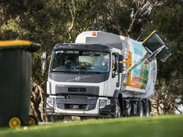 A waste vehicle collecting a recycling bin.
