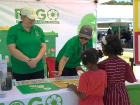 Two FOGO staff at a community event, telling kids about FOGO