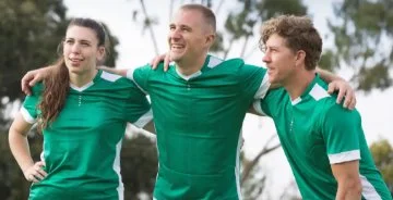 Three sports teams members with their arms around each others shoulders