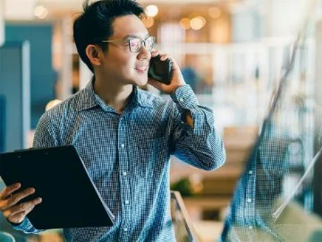 A business man on the phone holding a tablet