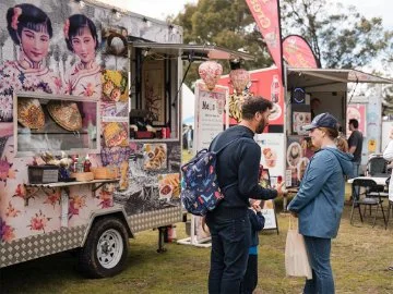 Food trucks and attendees at an outdoor event