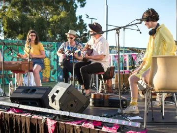 A band playing instruments on an outdoor stage