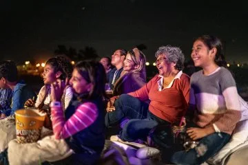 Group of people enjoying a movie at the outdoors cinema