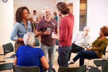 People standing at sitting engaging in conversation