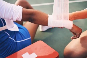 A persons wrist receiving first aid