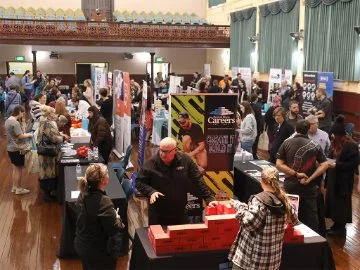 A photo from Swan Jobs Expo in 2025 showing stall holders talking to members of the public