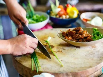 Chicken and vegetables being prepares on a wooden chopping board