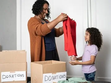 A mother and child declutter by donating clothing