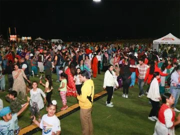 A community event with people dancing on an oval