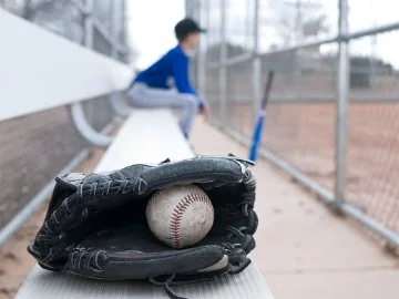 A teeball mitten placed on a grandstand bench