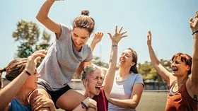 Female soccer players celebrating victory on a soccer field