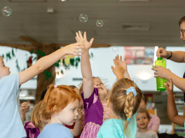 Children playing with bubbles in a library