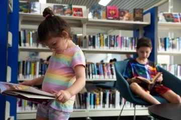 Children reading books inside a library