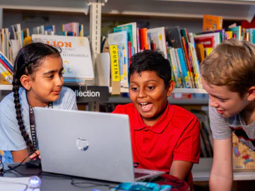 Chlidren using a laptop in a library space