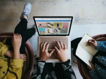 top down view of people around a laptop