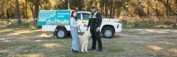 Pet owner standing with dog next to a ranger