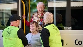 People standing next to a bus