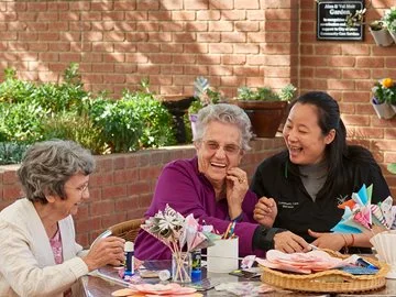 Laughing seniors at Swan Caring with a City worker