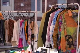A variety of clothes hanging on racks at a Clothes Swap
