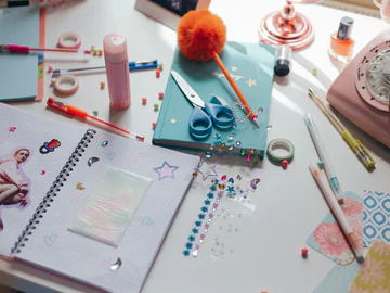An open scrapbook surrounded by art and craft materials