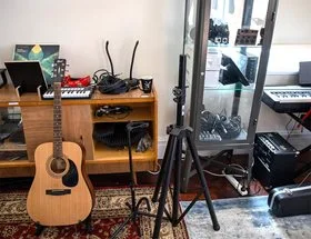 Inside the Midland Courtyard Studio showing a guitar, a keyboard, and other musical recording instruments