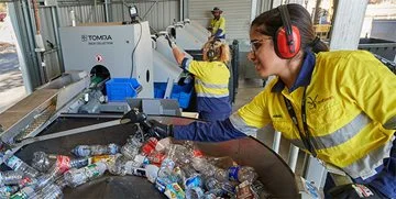 A worker separates cans and bottles at a cash for containers workshop