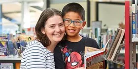 A mother and child reading a book in a Beechboro Library