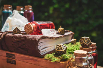 An image of a book, dices and potion bottles.